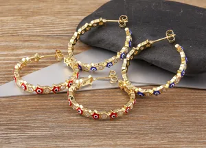Detailed view of copper gold plated evil eye pentagram hoop earrings with sparkling zirconia.