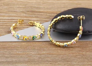 Detailed close-up of gold-plated evil eye heart hoop earrings with colorful cubic zirconia.