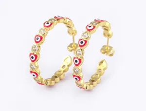 Close-up detail of gold plated heart evil eye hoop earrings with sparkling cubic zirconia stones.