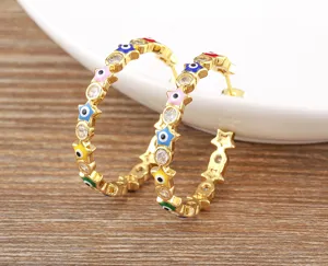 Detailed view of gold-plated star evil eye hoop earrings with sparkling cubic zirconia stones.