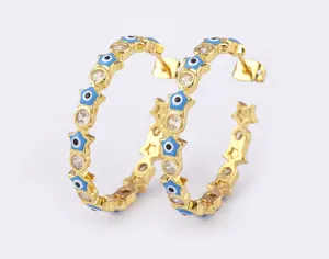 Gold plated evil eye hoop earrings with sparkling zirconia and blue star details for daily wear.