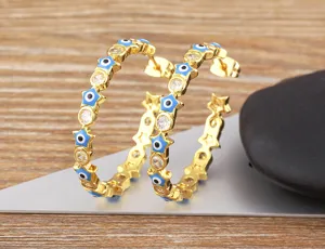 Gold-plated evil eye star hoop earrings detailed shot, minimalist fashion jewelry design.
