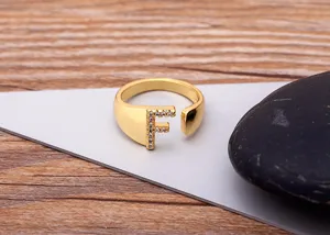 Detailed close-up of the gold-plated letter F open ring paved with sparkling cubic zirconia.