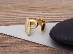 Close-up detail of the gold-plated open ring featuring a bold letter P design on a modern display.