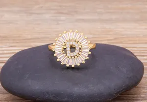 Close-up detail of a gold-plated letter D cubic zirconia ring displayed on a dark stone.