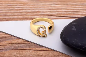 Detailed view of the gold plated open letter Q ring adorned with sparkling zirconia.