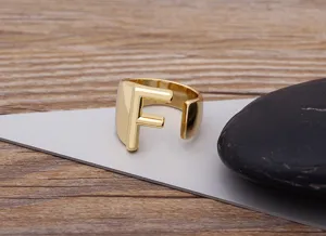 Detail shot of the gold-plated open letter F ring showcasing its polished finish and texture.
