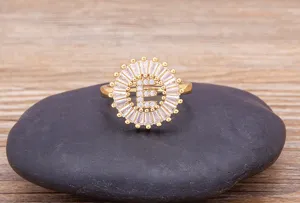 Gold plated brass ring featuring sparkling cubic zirconia stones and a letter E center design.