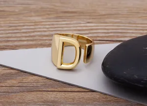 Close-up detail of the chunky gold-plated alphabet D initial open ring on a display surface.