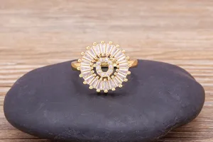Close-up detail of the 18k gold plated letter O zircon ring displayed on a smooth black stone.