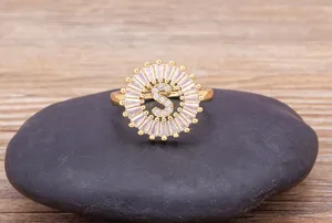 Close-up detail view of the 18K gold plated letter S zircon ring on a dark stone surface.
