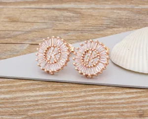 Primer plano de pendientes de tuerca con letra K chapados en oro de 18k con circonitas blancas.