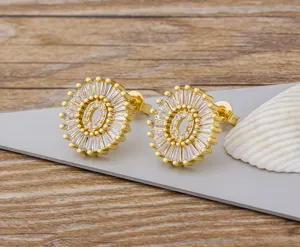Primer plano detallado de los pendientes de letra O chapados en oro de 18k con circonitas.