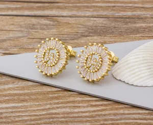 Vista detallada de los elegantes pendientes de botón letra W chapados en oro con circonitas micro.