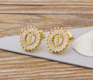 Pendientes de boton con letra T chapados en oro con detalles de circonita cubica micro.