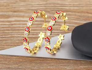 Gold-plated hoop earrings featuring red star evil eye enamel and clear cubic zirconia stones.