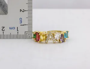 Primo piano dell'anello con lettera A placcato in oro e zirconi colorati con righello.