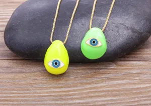 Evil eye pendant necklace close up, teardrop enamel gold plated chain jewelry detail view.