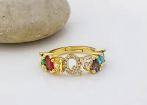 Primo piano dettagliato dell'anello con lettera Q placcato oro e zirconi colorati.