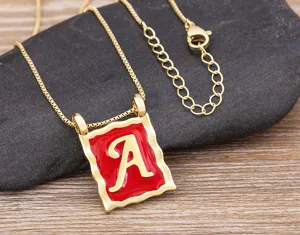 Detailed view of the retro 18k gold plated square letter A necklace with red oil drop design.