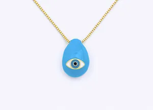 Detailed view of the blue teardrop evil eye pendant and gold chain necklace craftsmanship.