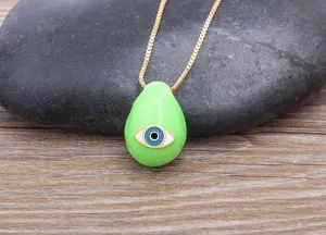 Gold plated evil eye pendant necklace, green teardrop charm, detailed close-up shot.