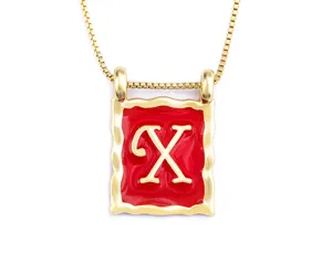 Gold-plated square letter necklace detail showcasing vibrant red enamel and polished finish.