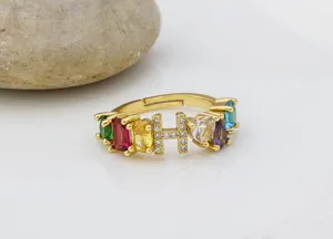 Primo piano dettagliato dell'anello con lettera H placcato in oro 18k e zirconi colorati.