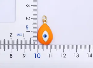 Close-up detail of the orange enamel evil eye pendant with golden finish and clear size scale.