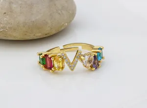 Primo piano dettagliato di anello in zircone colorato lettera V stile europeo dorato.
