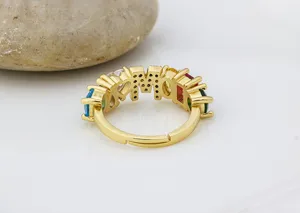 Dettaglio ravvicinato dell'anello con lettere in zirconi colorati placcato oro, chic.