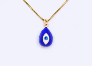Close-up detail of gold plated evil eye teardrop pendant necklace featuring elegant blue enamel.