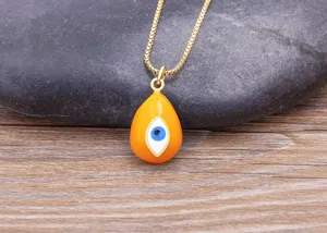 Gold plated teardrop evil eye necklace detail close-up showing yellow enamel pendant charm