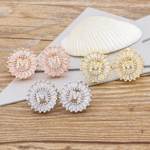Elegantes pendientes de botón con letra M de circonita micropavé en oro, plata y oro rosa.
