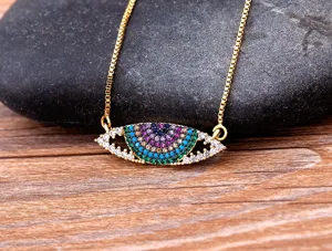 Collier pendentif mauvais œil, vue rapprochée détaillée montrant des zircons et chaîne dorée.