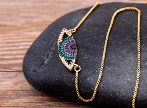 Gros plan détaillé d'un collier mauvais œil plaqué or avec oxydes de zirconium.