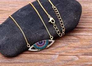 Gros plan détaillé du collier pendentif œil maléfique en cristal coloré avec chaîne.