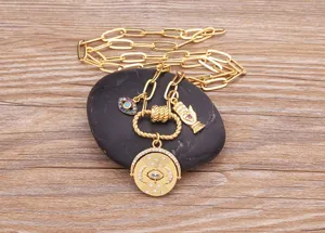 Primo piano della collana a catena spessa con malocchio e ciondoli a disco girevole.