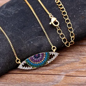 Colliers mauvais œil plaqué or avec oxydes de zirconium colorés sur fond de pierre sombre.
