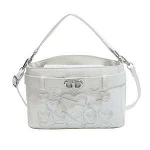 White women crossbody shoulder bag with heart embroidery and twist lock, stylish top handle.