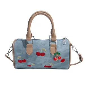 Chic denim boston bag with cherry embroidery and shoulder strap for women main view.