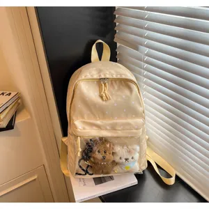 Detailed closeup view of yellow polka dot backpack featuring transparent front pocket.