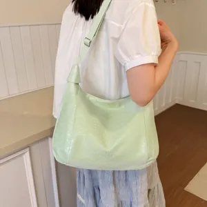 Light green shoulder crossbody bag detailed view featuring soft texture and adjustable strap.