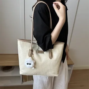 Schicke gewebte Damentasche, stilvolle minimalistische Schultertasche mit süßem Plüschanhänger.