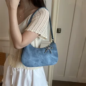 Chic blue shoulder underarm handbag for women, featuring a stylish beaded bow pendant design.