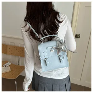Back view detail showing cute light blue polka dot backpack with star pendant and bow charm.