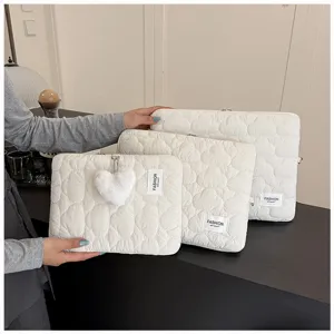 Primer plano detallado de fundas acolchadas blancas para portátiles con gran corazón.