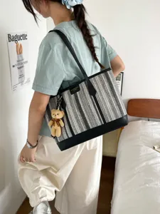 Stylish woven tote bag for women, large capacity commuter shoulder bag with cute bear charm.