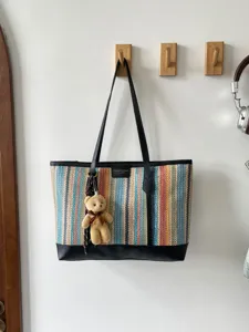 Woven tote bag for women, large capacity shoulder handbag with cute bear pendant detail.