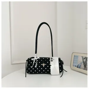 Detailed view of black polka dot shoulder bag with cute lace bow and heart charm accessory.